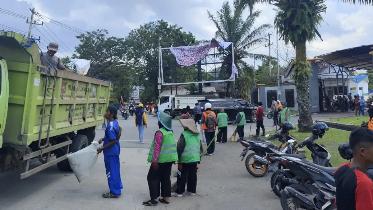 GERAK CEPAT: Puluhan personel DLH Samarinda menyapu jalan membersihkan sisa gelas air minum pendemo di depan Kantor DPRD Kaltim, Selasa (21/4).DENNY SAPUTRA/KALTIM POST