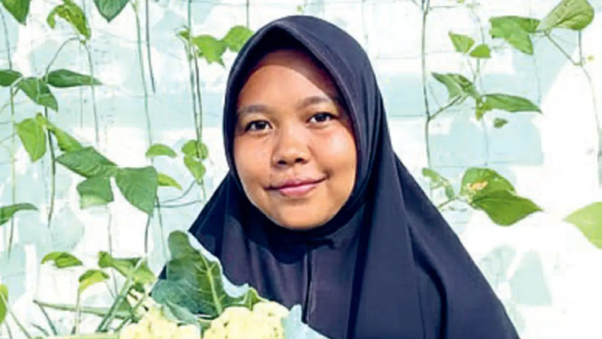 Umi menunjukkan beberapa sayur dan buah yang berhasil ditanam. Salah satunya stroberi. (JAWAPOS)
