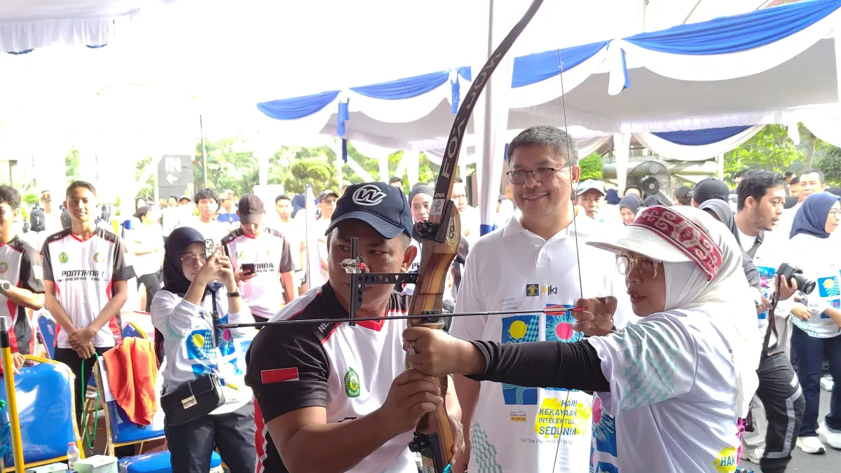 Kakanwil Kemenkum Kalbar Jonny Pesta Simamora bersama Ketua TP PKK Kalbar Erlina Ria Norsan menjajal panahan di salah satu klub olahraga dalam Mobile Intelektual Property Clinic Kanwil Kemenkum Kalbar di CFD Ayani Megamal Pontianak pada Minggu (26/4). (FOTO: MIFTAH/PONTIANAK POST)