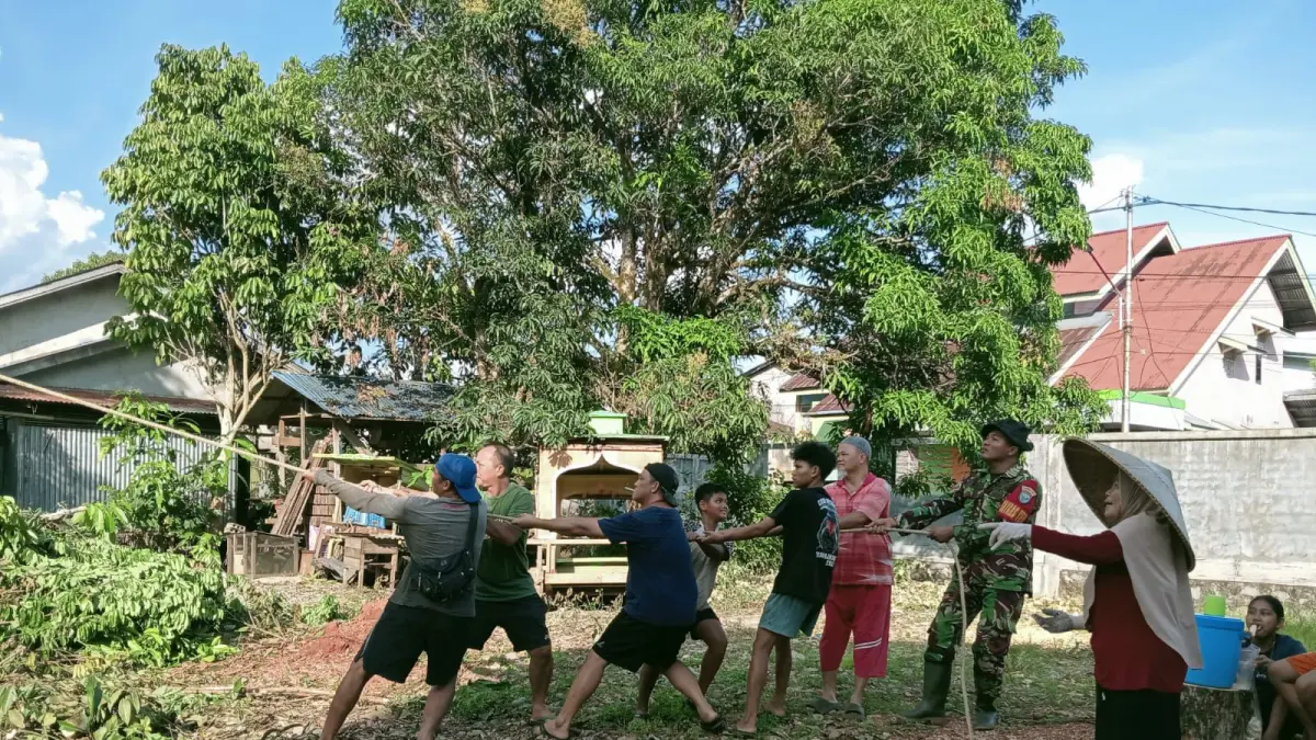 Kopda David Babinsa Koramil Putussibau Utara saat bersama masyarakat ikut gotong royong membuka lapangan volly. (ISTIMEWA)