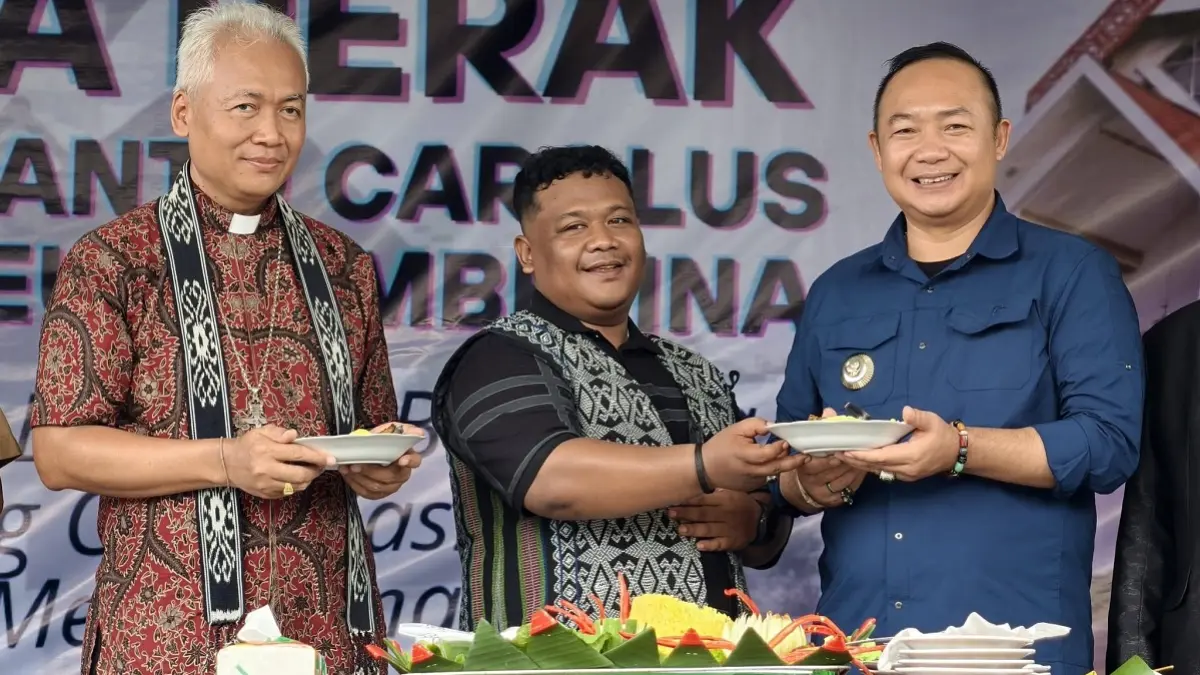 Bupati Ketapang, Alexander Wilyo, menerima potongan tumpeng pada Pesta Perak ke-25 Paroki Santo Carolus Borromeus Tembelina, Sungai Melayu Rayak, Selasa (28/4). (ISTIMEWA)