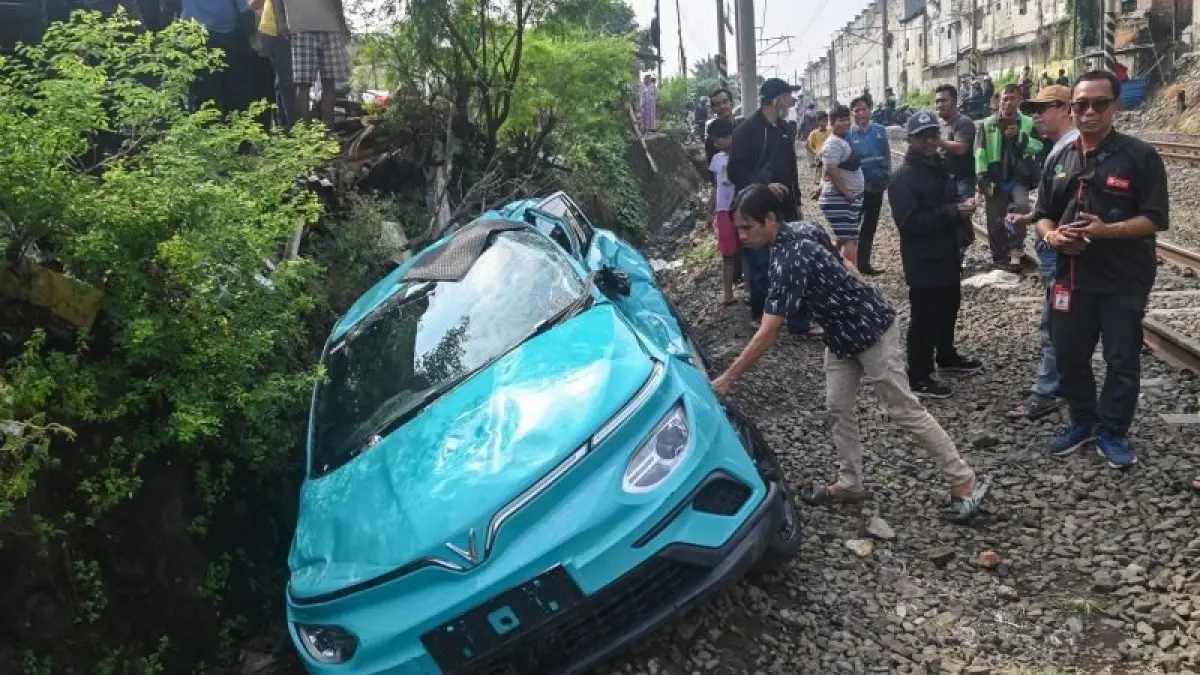 Warga mengamati taksi listrik Green SM yang rusak pascakecelakaan dengan KRL Commuter Line dan KA Argo Bromo Anggrek di Bekasi Timur, Bekasi, Jawa Barat, Selasa (28/4/2026). (ANTARA FOTO/FAKHRI HERMANSYAH)
