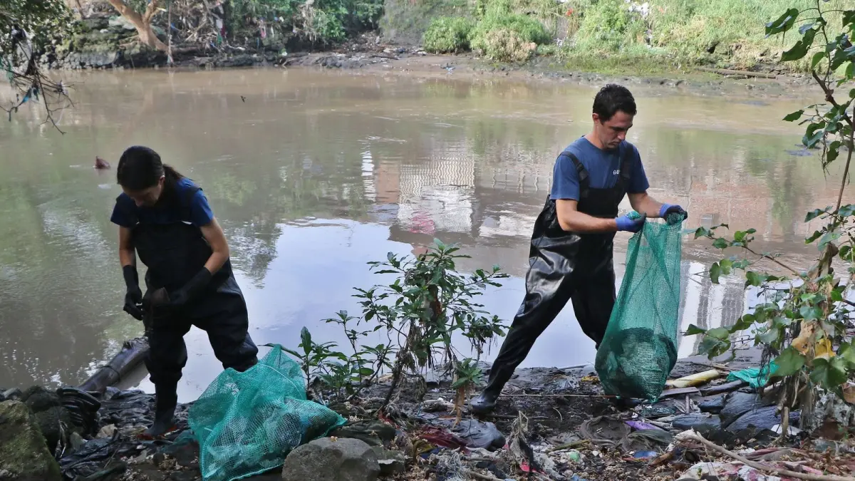Gary, Kelly, Sam membersihkan Kali Jalar Lama di Desa Kramat, Grobogan, Jawa Tengah, bersama para relawan lain, Rabu (29/04/2026). (JAWA POS)