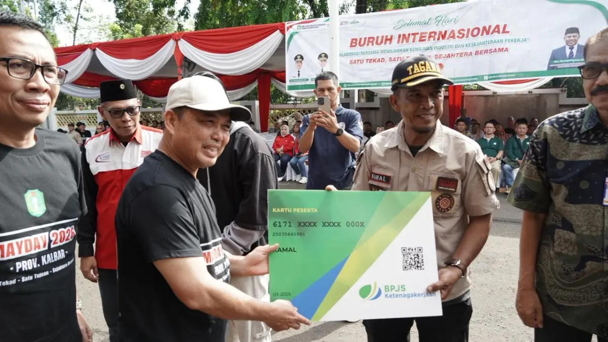Gubernur Kalbar Ria Norsan menyerahkan secara simbolis kartu BPJS Ketenagakerjaan, saat menghadiri peringatan May Day 2026 di Pontianak, Jumat (1/5/2026).