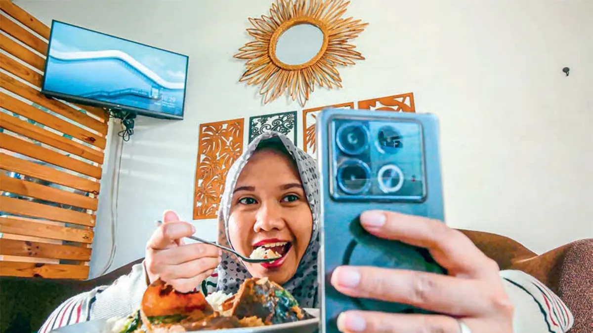 Ilustrasi makan sambil nonton video di ponsel (DOK JAWAPOS)