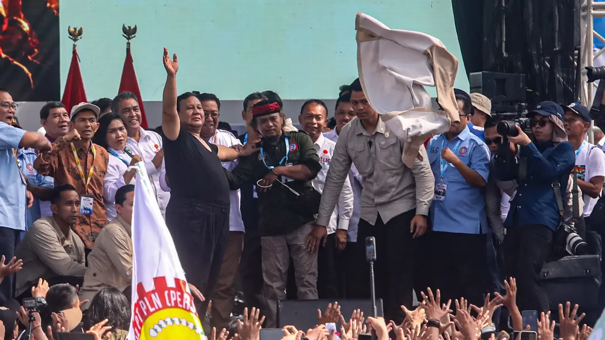 Presiden Prabowo Subianto membuka kemejanya dam melemparkan ke arah massa buruh saat peringatan Hari Buruh Internasional 2026 di kawasan Monumen Nasional (Monas), Jakarta, Jumat (1/5/2026).  (DERY RIDWANSAH/JAWA POS)