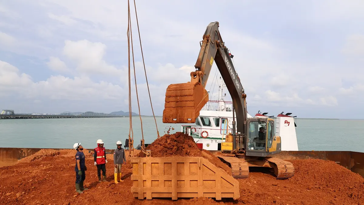Sejumlah pekerja mengawasi proses ekskavator melakukan aktivitas bongkar muat bauksit untuk dibawa ke PT Borneo Alumina Indonesia (BAI) di Pelabuhan Kijing, Kabupaten Mempawah, Kalimantan Barat. (ANTARA FOTO/JESSICA WUYSANG)