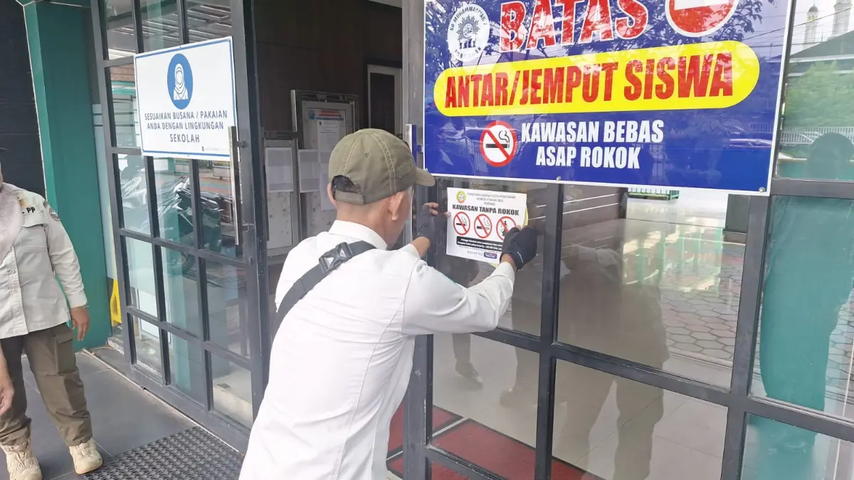 Tim Satgas Kawasan Tanpa Rokok (KTR) tengah menempelkan tanda larangan merokok sebagai implementasi Perda Nomor 4 Tahun 2025 tentang KTR. (ISTIMEWA)