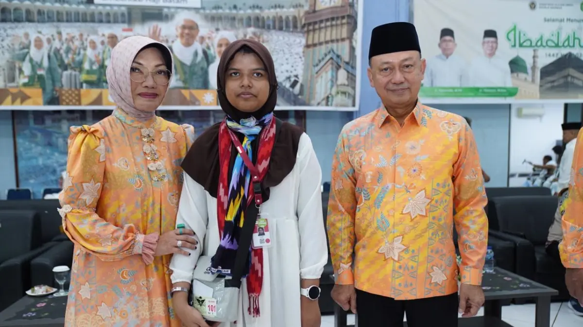 Aila Afifah berfoto bersama Edi Rusdi Kamtono dan istri sebelum keberangkatan menuju Tanah Suci di Embarkasi Batam, Jumat (8/5). Aila berangkat haji di usia 13 tahun sambil membawa doa untuk almarhumah ibunya.