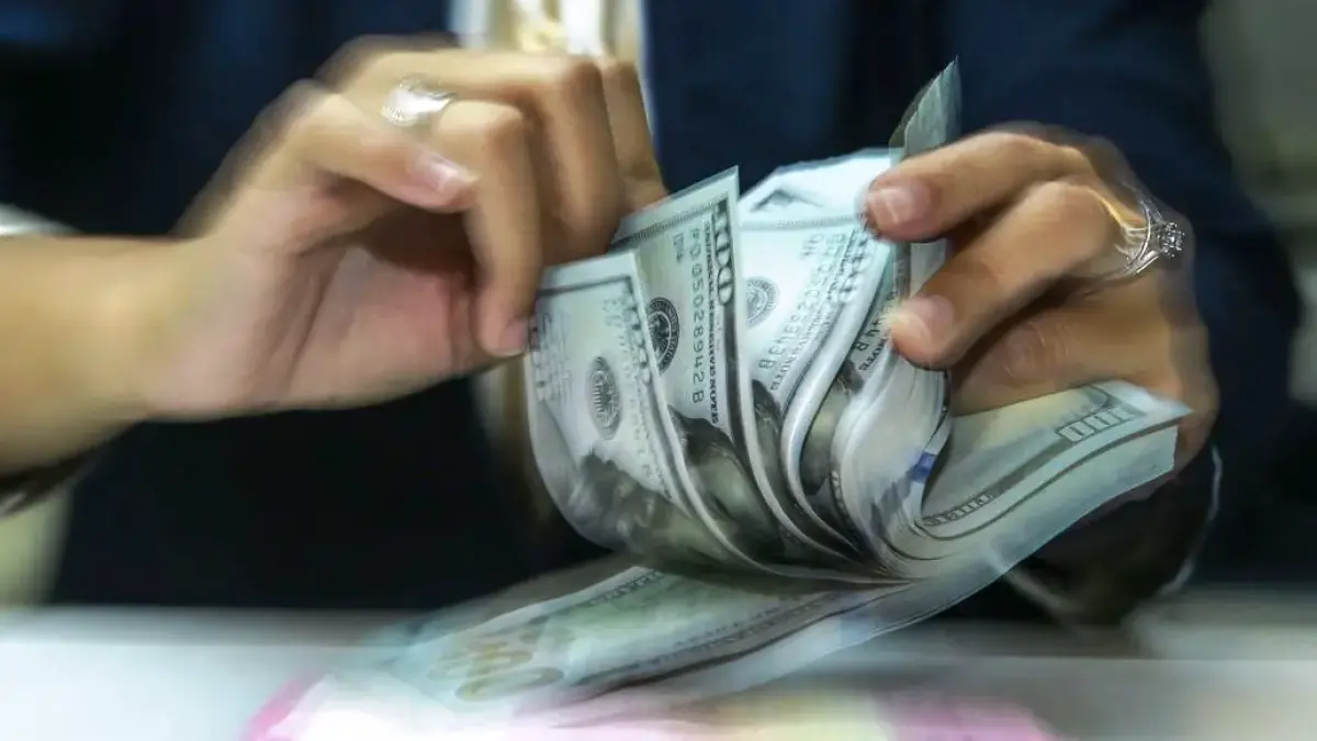 Karyawan menghitung uang pecahan rupiah dan dolar AS di gerai penukaran mata uang di Jakarta, Selasa (5/5/2026). (ANTARA)