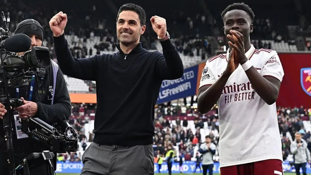 Mikel Arteta berselebrasi usai timnya menang saat menghadapi West Ham, Minggu (10/5).