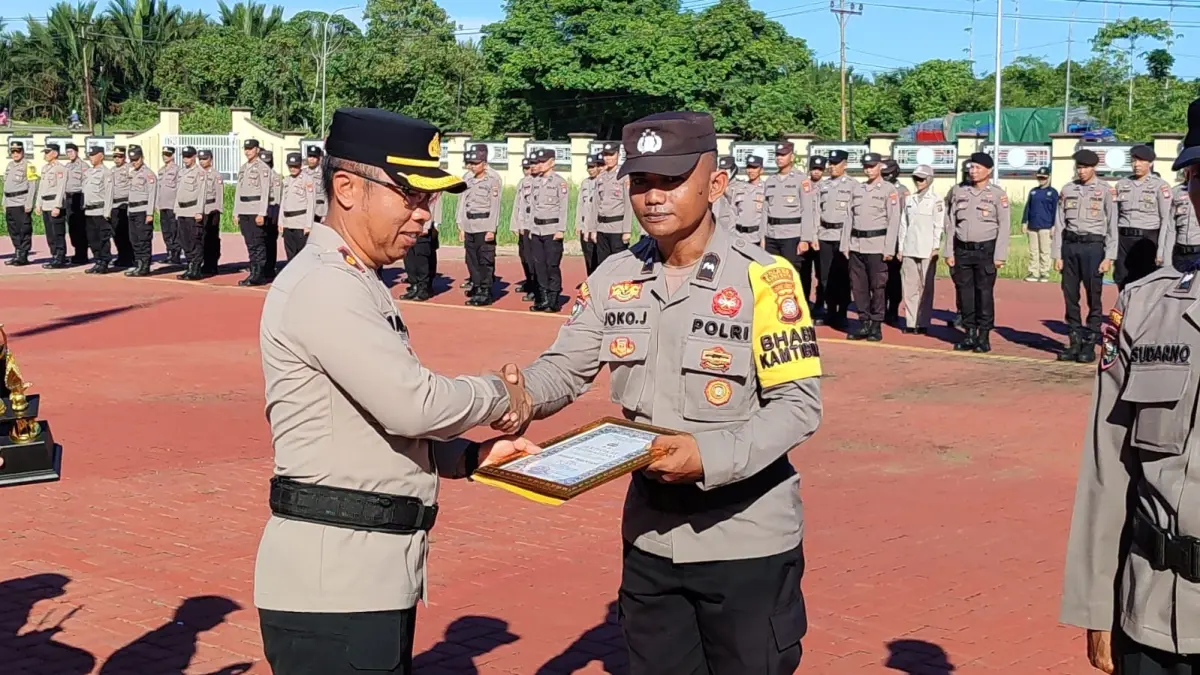 Wakapolres Kubu Raya, Kompol Andry Syahroni menyerahkan penghargaan juara pertama Lomba Satkamling kepada perwakilan Polsek Terentang, Aipda Joko Julianto, Senin (11/5). (ISTIMEWA)