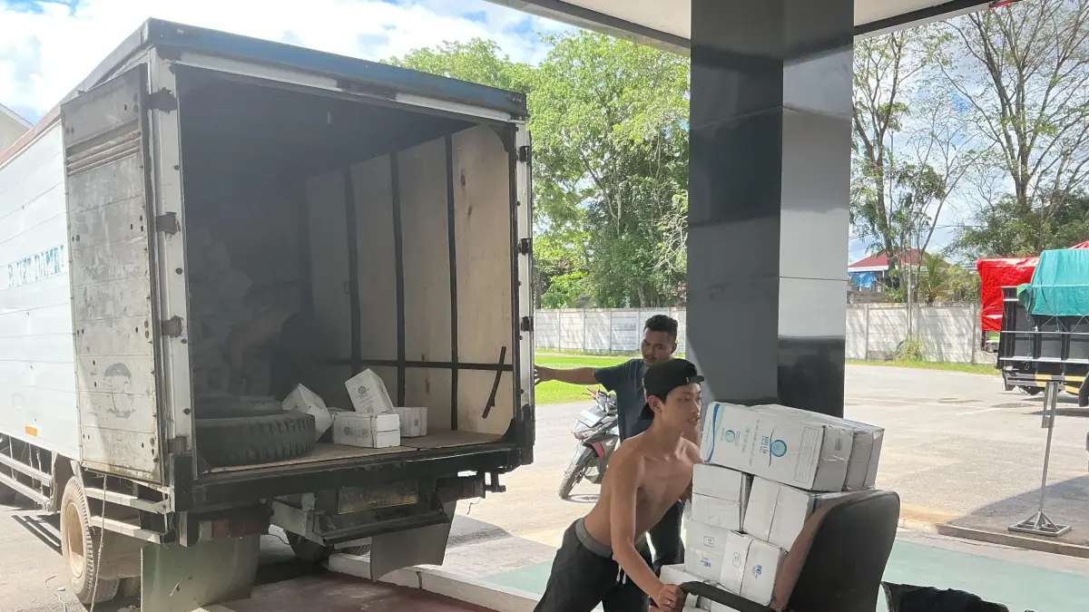 Petugas menurunkan dus air zamzam di Asrama Haji Transit Pontianak, Kamis (14/5). Distribusi dilakukan bertahap untuk memenuhi kebutuhan ribuan jemaah haji asal Kalimantan Barat tahun 2026. (Marsita/Pontianak Post)