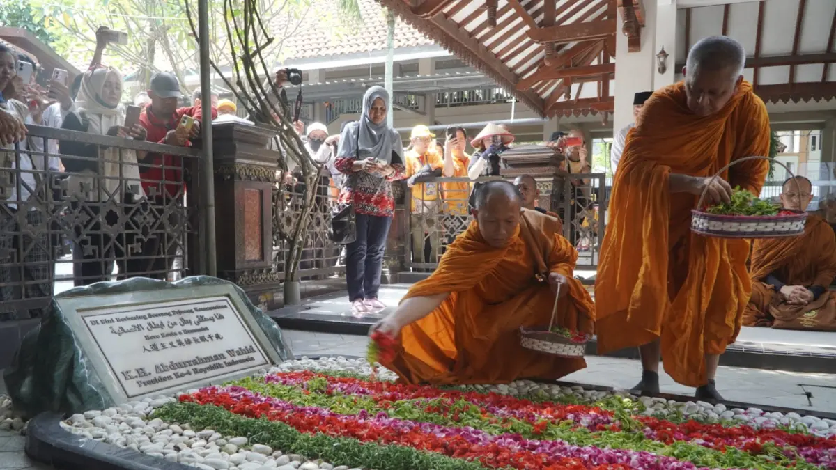 Bhante dan biksu peserta Indonesia Walk for Peace 2026 menaburkan bunga di makam Abdurrahman Wahid atau Gus Dur di kompleks Pondok Pesantren Tebuireng, Senin (19/5). Prosesi doa lintas iman itu menjadi simbol penghormatan terhadap warisan toleransi, pluralisme, dan perdamaian yang terus dikenang hingga kini. (FOTO: JAWA POS)