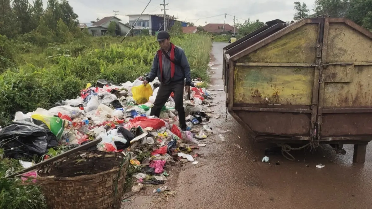 Petugas Dinas Lingkungan Hidup saat mengangkut sampah yang dibuang masyarakat disisi jalan. (ISTIMEWA)