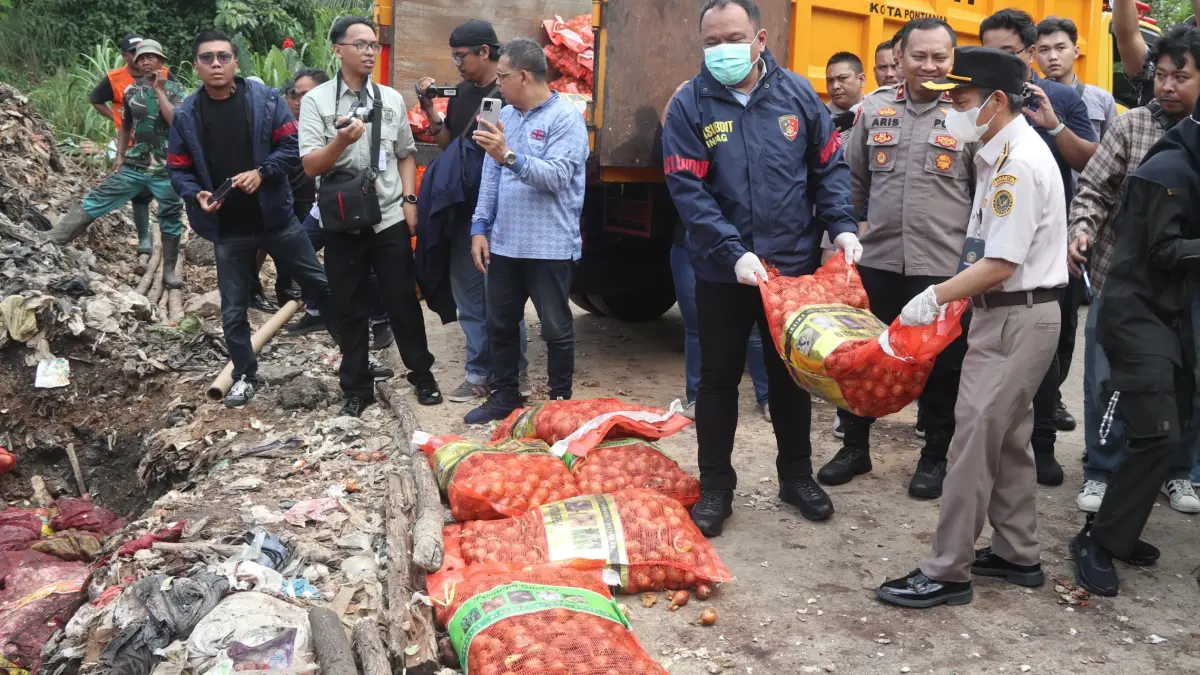 Petugas gabungan dari Bareskrim Polri bersama sejumlah instansi terkait memusnahkan bawang impor ilegal asal Malaysia dengan cara dikubur di TPA Batu Layang, Kamis (21/5). (POLDA KALBAR FOR PONTIANAK POST)