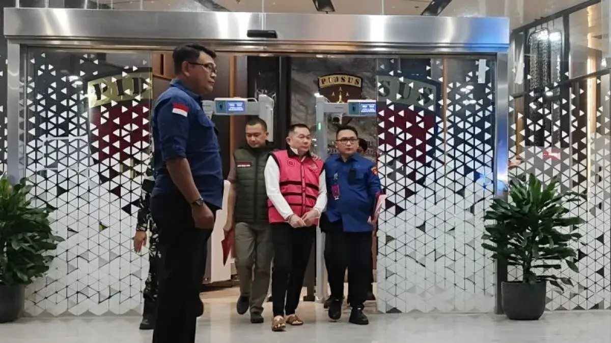 Tersangka kasus dugaan korupsi penyimpangan tata kelola izin usaha pertambangan (IUP) PT QSS di Kalimantan Barat tahun 2017–2025, SDT (tengah), digiring oleh petugas menuju mobil tahanan di Gedung Jampidsus Kejagung, Jakarta, Kamis (21/5/2026). ANTARA/Nadia Putri Rahmani