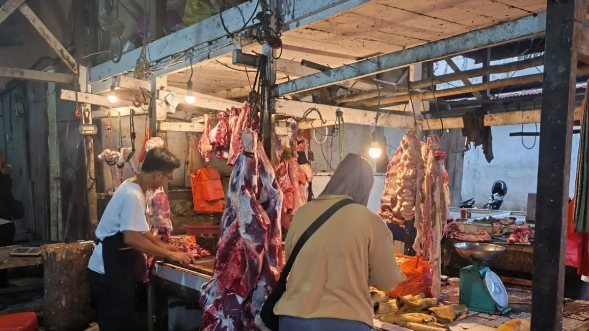 Pedagang daging sapi lokal, Syahri, saat melayani pembeli di pasar tradisional Sanggau, Sabtu (23/05/2026). 