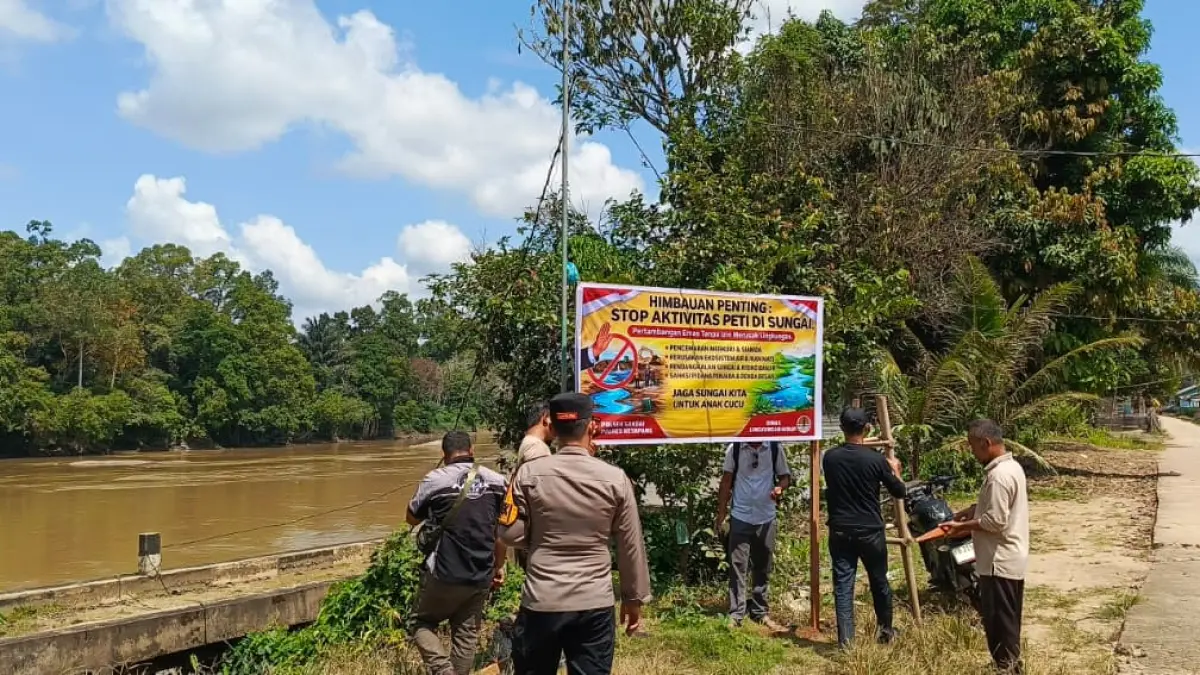 LARANG PETI: Personel Polsek Sandai bersama Pemerintah Desa Penjawaan memasang papan imbauan larangan Pertambangan Emas Tanpa Izin (PETI) di sepanjang aliran Sungai Pawan, Kecamatan Sandai, Kabupaten Ketapang, Senin (1/6). Polisi menegaskan tidak ada toleransi bagi aktivitas tambang ilegal yang merusak lingkungan dan melanggar hukum. (IST)