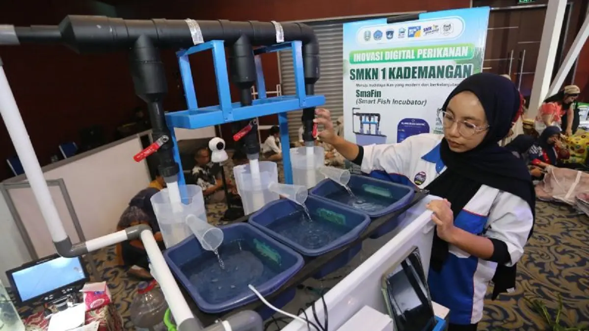 Pelajar SMK Negeri 1 Kedemangan, Blitar Ivhen Angel Merlynda menunjukkan cara kerja inovasi alat penetasan telur ikan berbasis IoT bernama Smafin (Smart Fish Incubator) saat pameran SMK Hebat Jawa Timur 2026 di Surabaya, Jawa Timur, Sabtu (14/2). (ANTARA FOTO/Moch Asim/rwa).