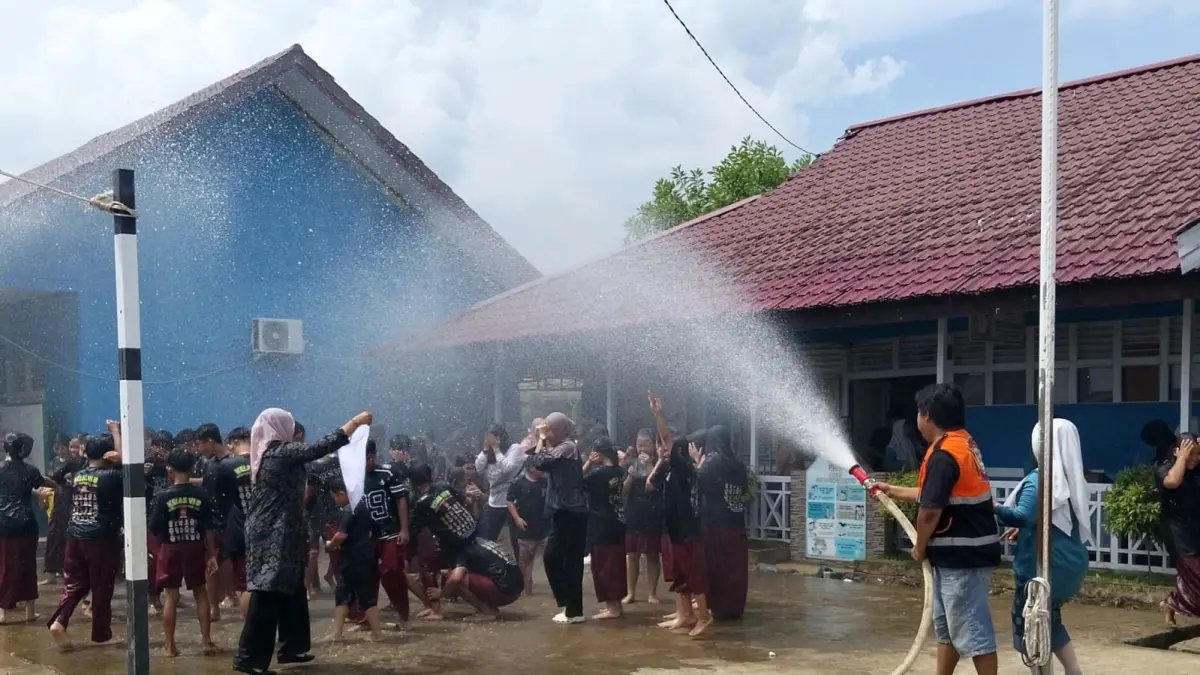 Muris dan guru SDN 01 Sungai Pinyuh merayakan kelulusan dengan basah-basahan.