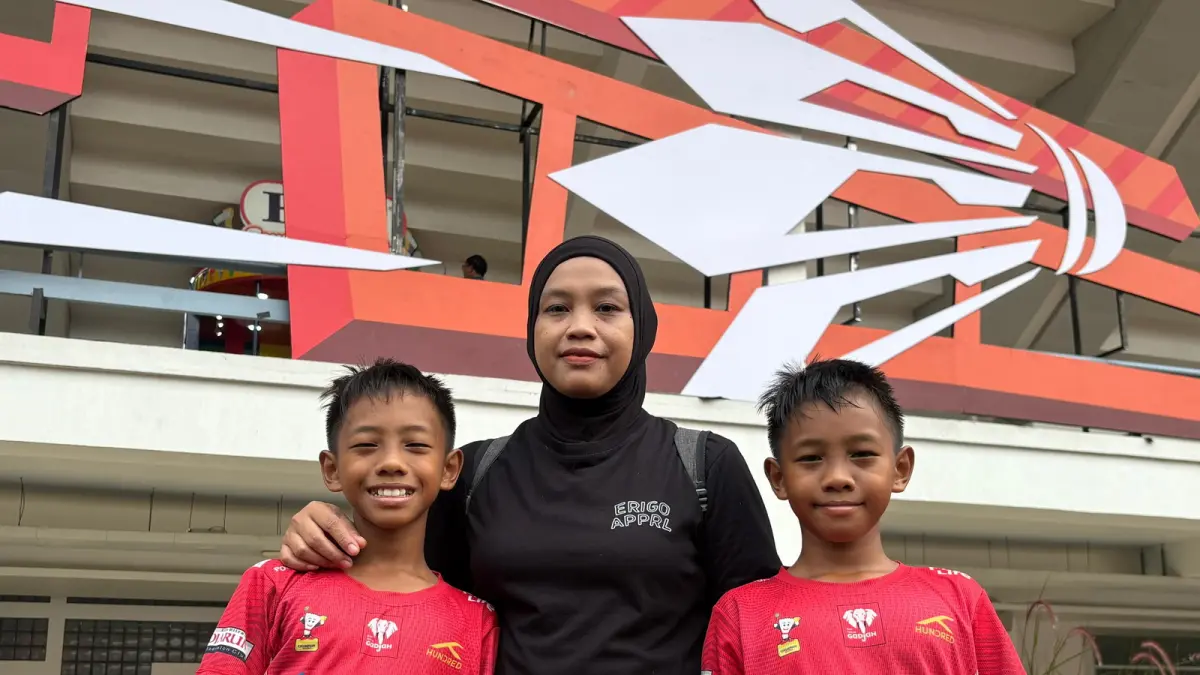 MENANAM MIMPI: Aisah Muslimah bersama kedua anak kembarnya, Ataya dan Atala, menyaksikan pertandingan Indonesia Open 2026 di Istora Gelora Bung Karno, Jakarta, kemarin. Mereka datang untuk belajar langsung dari para pebulutangkis dunia sekaligus memberi dukungan kepada wakil Indonesia. (JAWA POS)
