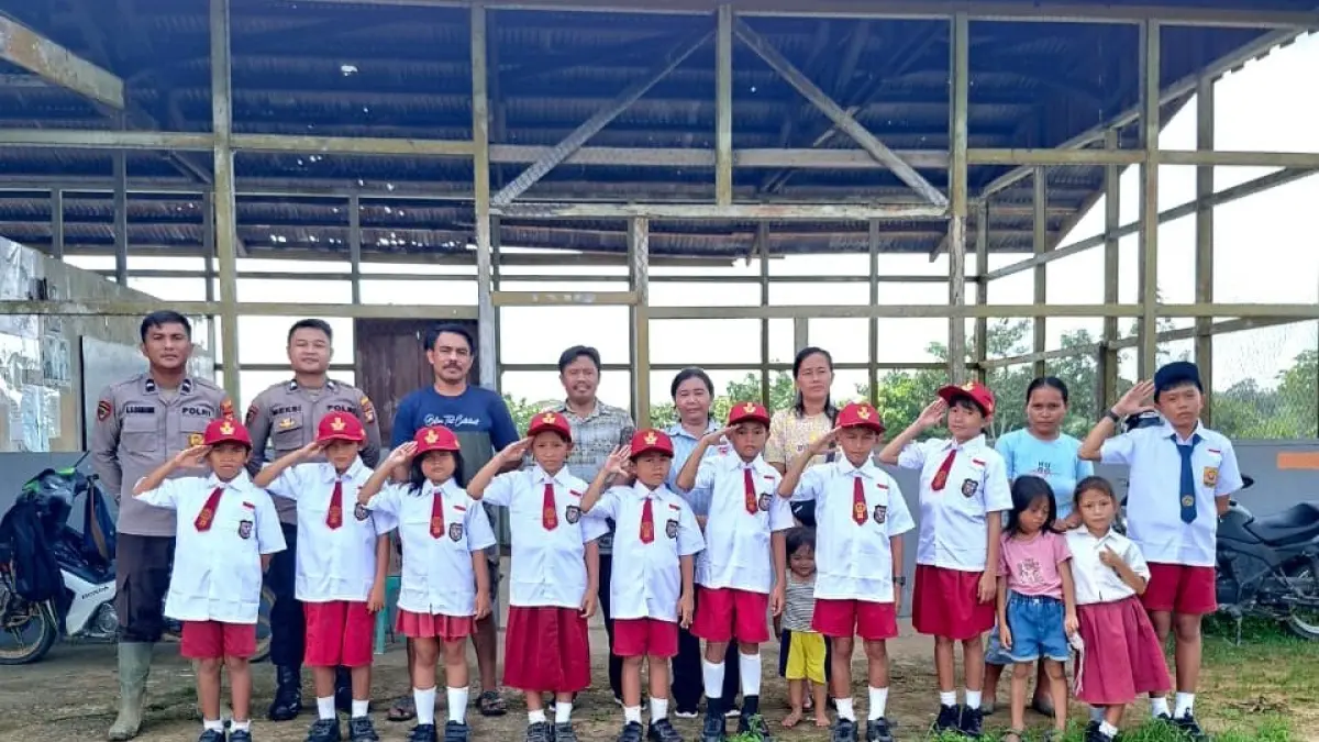 Guru, siswa, dan jajaran Bag SDM Polres Landak berfoto bersama di depan SD Bina Setia Labos, Desa Nyiin, Kecamatan Jelimpo, usai penyerahan bantuan seragam sekolah. Di sekolah sederhana yang hanya memiliki 13 siswa itu, bantuan tersebut menjadi simbol dukungan bagi perjuangan anak-anak pedalaman meraih masa depan melalui pendidikan. (Istimewa)