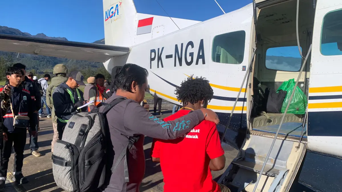 Petugas mengawal tersangka KKB saat diberangkatkan dari Bandara Aminggaru Ilaga menuju Timika untuk menjalani proses hukum lebih lanjut, Senin (8/6).