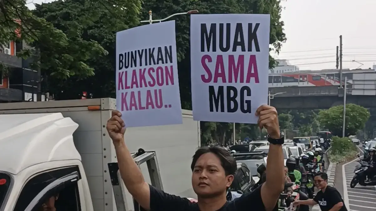 Aksi Protes: Massa dari koalisi masyarakat sipil yang tergabung dalam MBG Watch membentangkan poster bertuliskan ajakan membunyikan klakson sebagai simbol kekecewaan terhadap Program Makan Bergizi Gratis (MBG) di depan Kantor Badan Gizi Nasional (BGN), Kebon Sirih, Jakarta Pusat, Rabu (10/6/2026). Dalam aksi tersebut, sejumlah pengendara turut membunyikan klakson sebagai bentuk respons terhadap seruan yang disampaikan peserta aksi.(Dimas Choirul/Jawapos.com)
