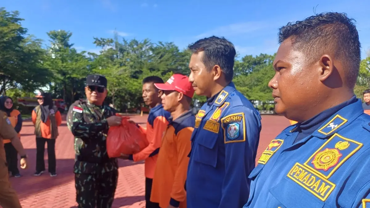 Bupati Kubu Raya, Sujiwo menyerahkan secara simbolis paket kebutuhan pokok kepada personel BPBD Kubu Raya usai Apel Kesiapsiagaan Karhutla di Halaman Kantor Bupati Kubu Raya, Senin (9/6). (Ashri Isnaini/Pontianak Post)