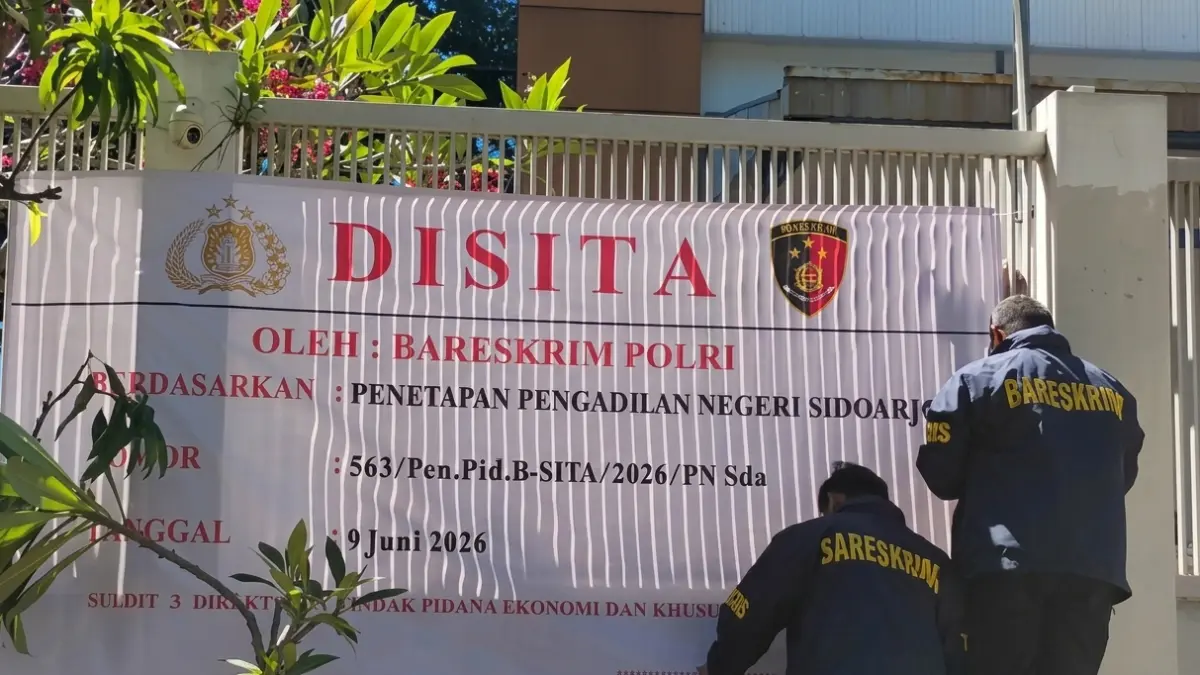 PENGEMBANGAN KASUS SIMAN BAHAR: Petugas Bareskrim Polri memasang spanduk penyitaan di fasilitas pemurnian emas PT Simba Jaya Utama (SJU), Sidoarjo, Jawa Timur, Kamis (11/6/2026). Penyitaan dilakukan dalam pengembangan kasus dugaan tambang emas ilegal dan pencucian uang yang turut menyeret nama almarhum Siman Bahar. (FOTO: ANTARA-Fahmi Alfian)