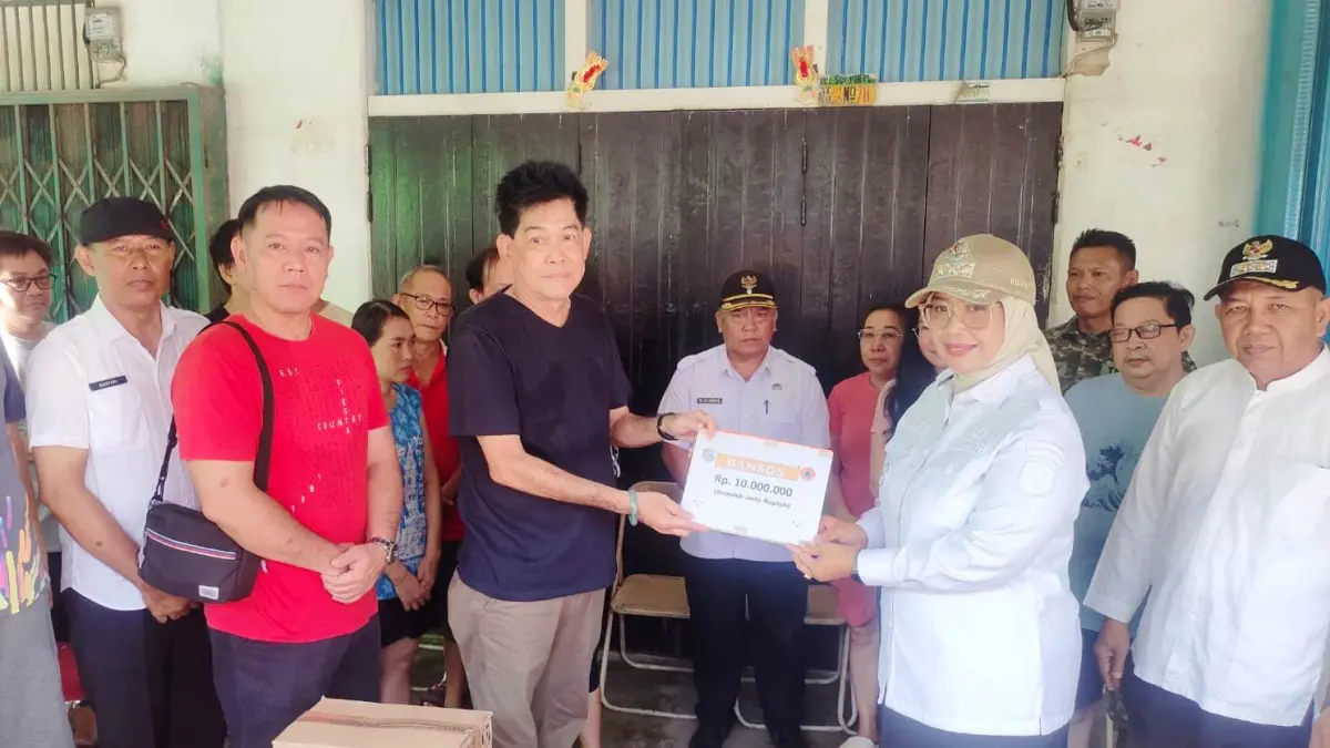 Bupati Erlina saat menyerahkan bantuan kepada korban kebakaran Pasar Pagi Sungai Pinyuh