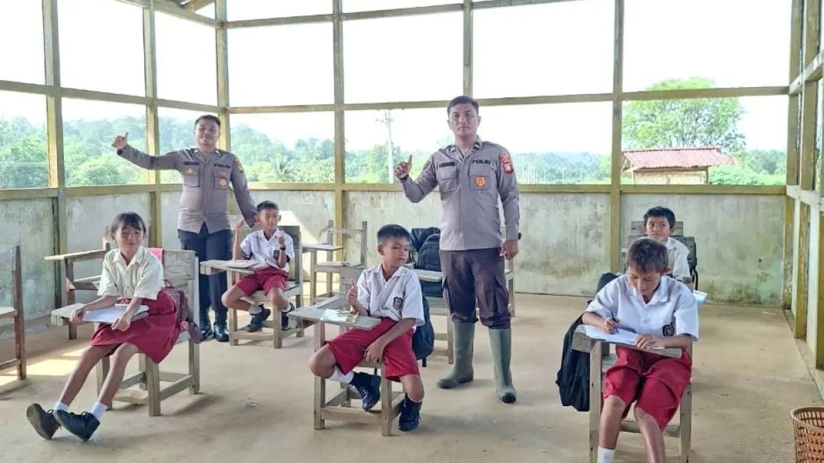 Personel Polres Landak menyerahkan bantuan seragam sekolah kepada Sisw SD Bina Setia Labos Desa Nyiin Kecamatan Jelimpo Kabupaten Landak pada Senin (1/6). (HUMAS POLRES LANDAK)