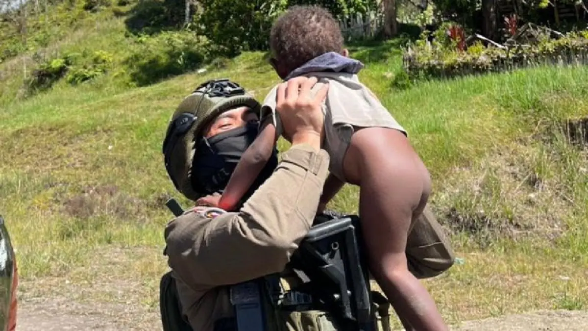Personel Satgas Operasi Damai Cartenz disela-sela patroli jalan kaki berkesempatan bercengkrama dengan anak-anak di Sinak, Kabupaten Puncak. (ANTARA/HO/Satgas Damai Cartenz)
