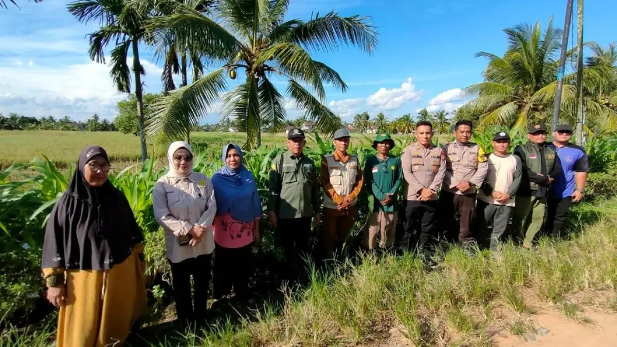 Kapolsek Sungai Pinyuh berfoto bersama saat meninjau lokasi penanaman jagung hibrida.