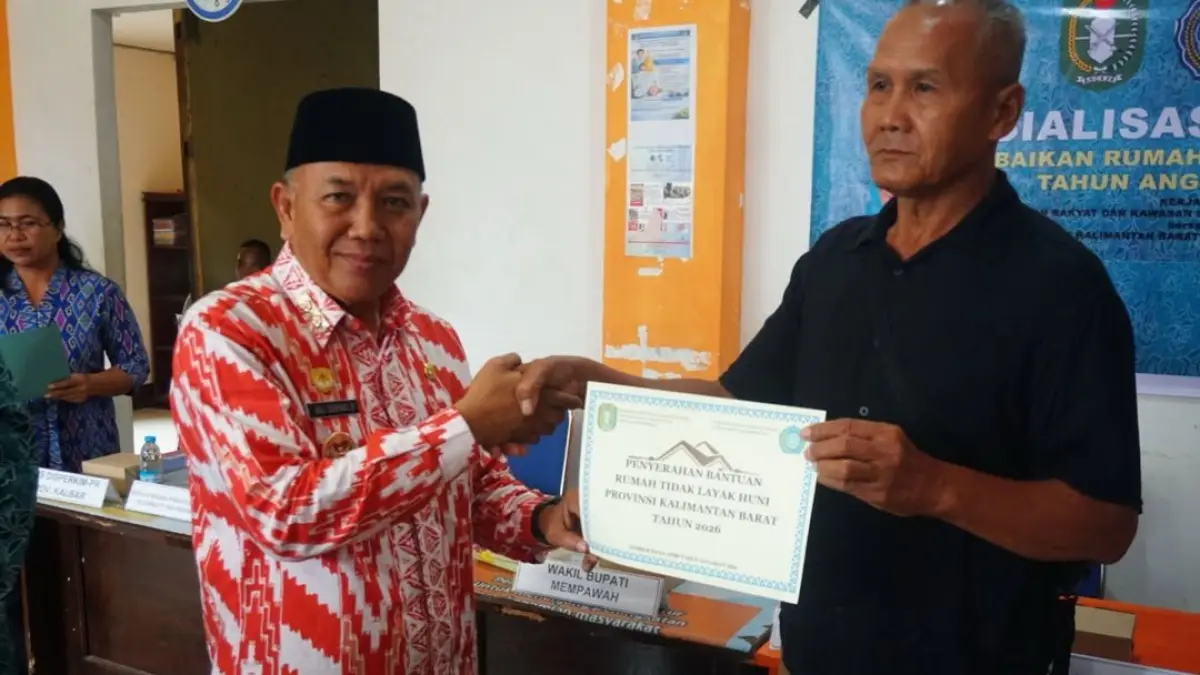 Wabup Juli Suryadi secara simbolis menyerahkan bantuan kepada warga penerima.