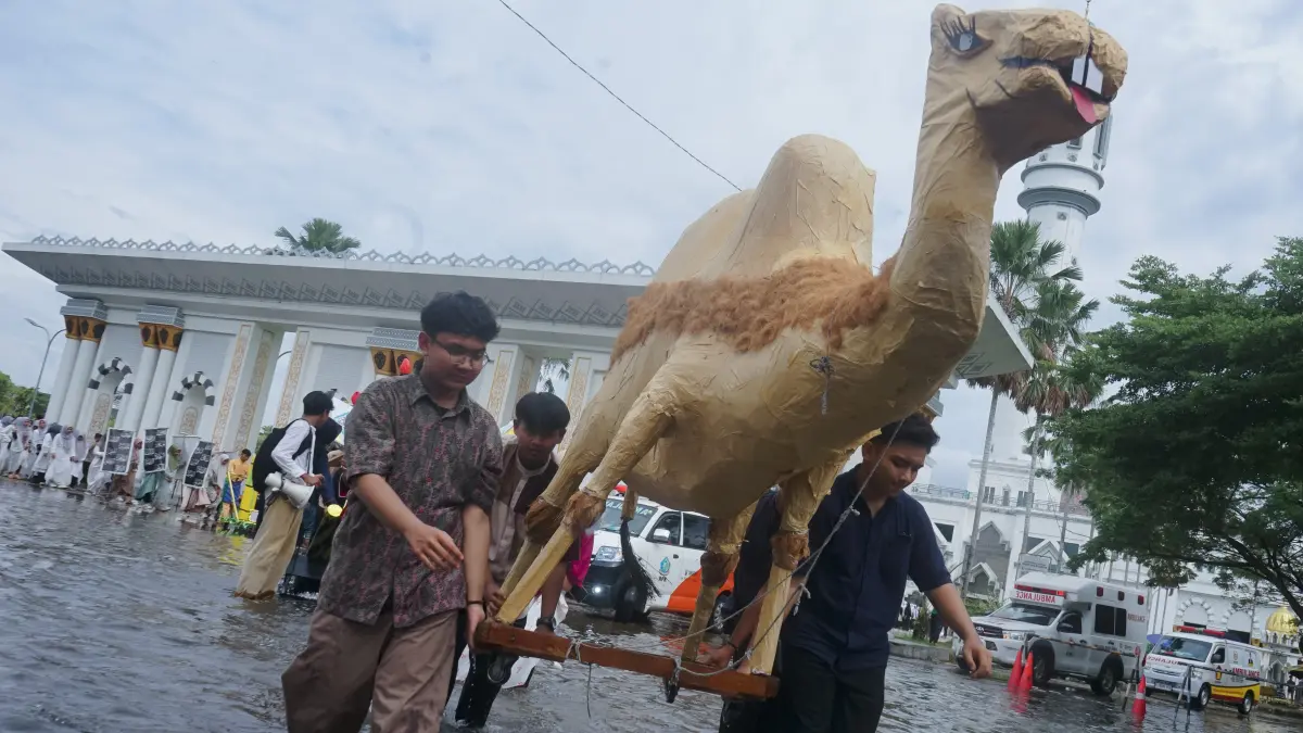 BANJIR PAWAI 1 MUHARRAM: Sejumlah peserta anak-anak dan remaja melintasi genangan banjir di Masjid Raya Mujahidin saat pelaksanaan pawai menyambut tahun baru Islam, Selasa (16/06/2026) .(HARYADI/PONTIANAK POST)