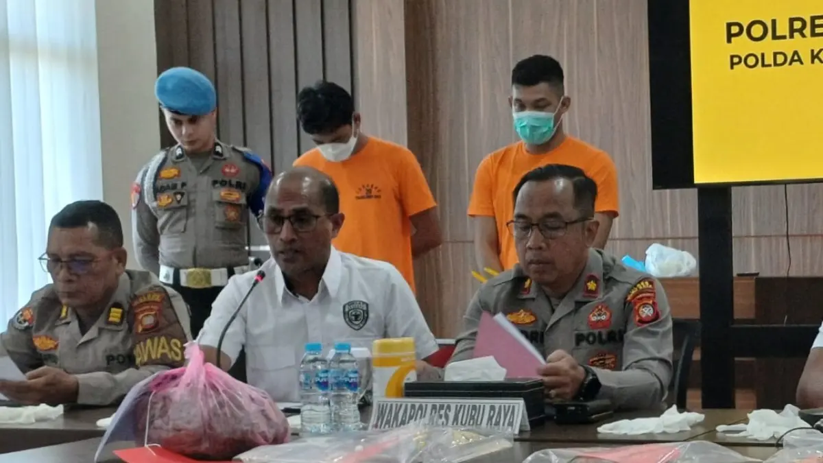 Pelaku ME (bermasker putih) menundukkan kepala saat dihadirkan dalam konferensi pers di Mapolres Kubu Raya, Rabu (17/6). Karyawan perkebunan sawit itu ditetapkan sebagai tersangka kasus penyiraman cairan kimia terhadap pasutri di Kecamatan Sungai Ambawang. (ASHRI ISNAINI/PONTIANAK POST)