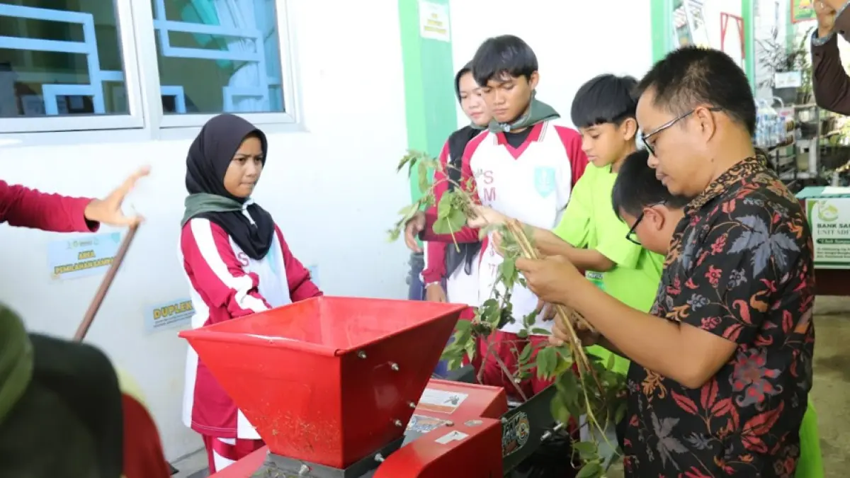PENGOLAHAN SAMPAH ORGANIK – Tim PKM Universitas Tanjungpura mendampingi guru dan siswa SDIT Al Mumtaz Pontianak mempraktikkan penggunaan mesin pencacah sampah organik untuk diolah menjadi kompos, Selasa (9/6/2026). Kegiatan ini bertujuan meningkatkan keterampilan pengelolaan sampah sekaligus menanamkan kepedulian lingkungan sejak usia dini.