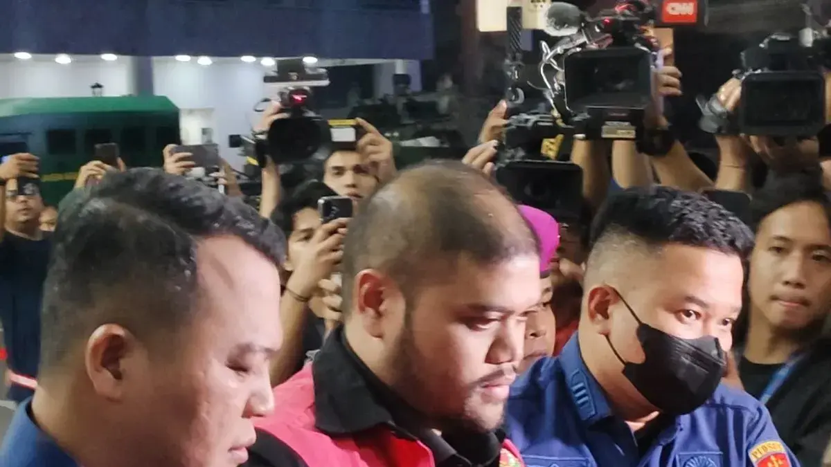 Petugas menggiring tersangka kasus dugaan korupsi tata kelola program Makan Bergizi Gratis (MBG) pada Badan Gizi Nasional (BGN) tahun 2025–2026, GHS (tengah), menuju mobil tahanan di Gedung Jampidsus Kejagung, Jakarta, Kamis (18/6/2026). (ANTARA)