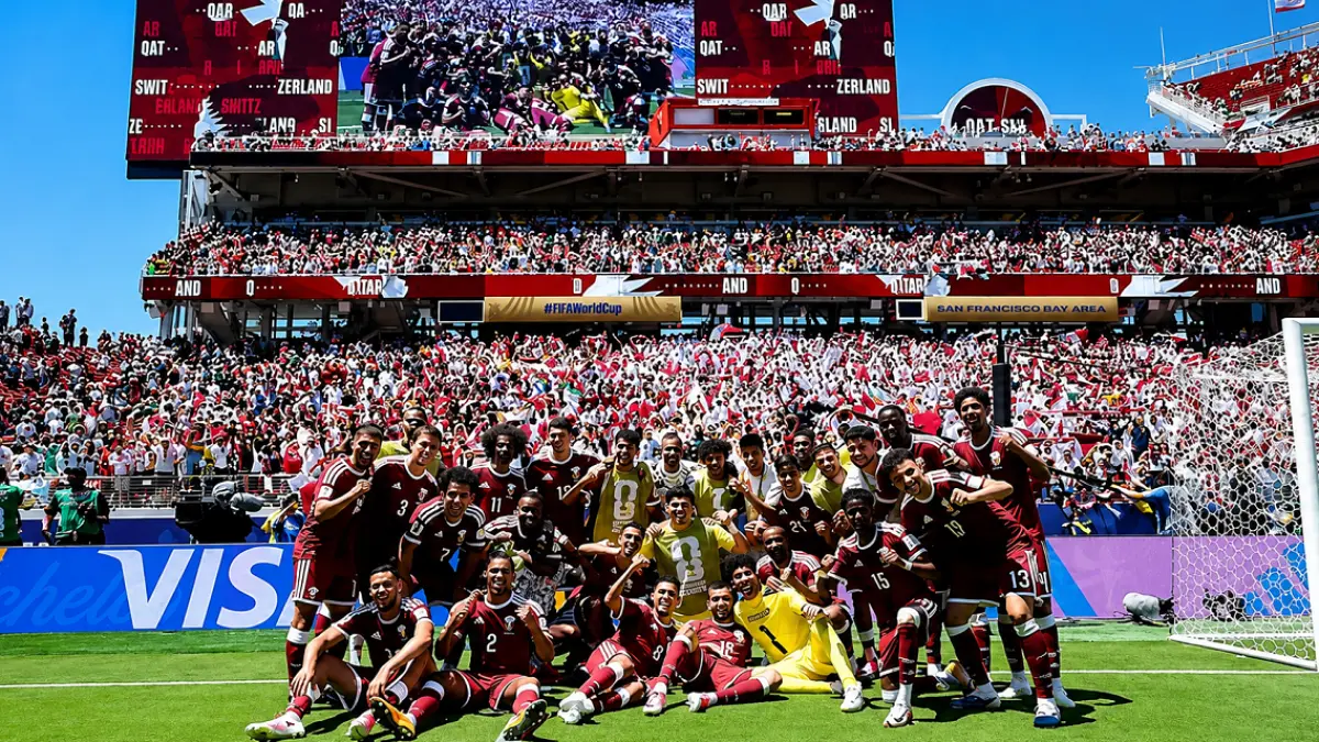 Timnas Qatar berpose dengan latar belakang pendukungnya usai bermain imbang 1-1 melawan Swiss pada laga perdana Grup B Piala Dunia 2026, Minggu (14/6). (IG @qfa)