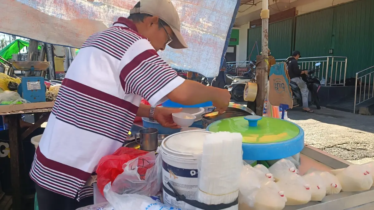 Aseng dengan cekatan menyiapkan hidangan Bubur Tahu. Usia tak menghalanginya berjualan.