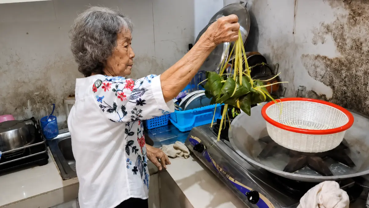 MENGUKUS BAKCANG: The Ngak Tjeng (87) mengangkat kukusan di dapur rumahnya di Pontianak. Dari tangan renta perempuan ini, tradisi dan nilai budaya Tionghoa terus diwariskan kepada generasi berikutnya.