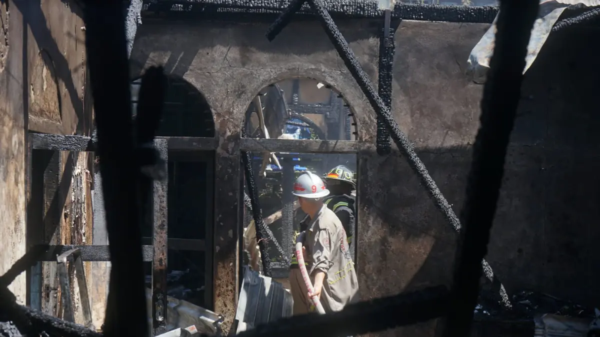 PENDINGINAN: Sejumlah petugas pemadam kebakaran melakukan penyiraman air disudut rumah yang terbakar di Jalan Mujahidin,Minggu(21/6).(HARYADI KLIK/PONTIANAKPOST