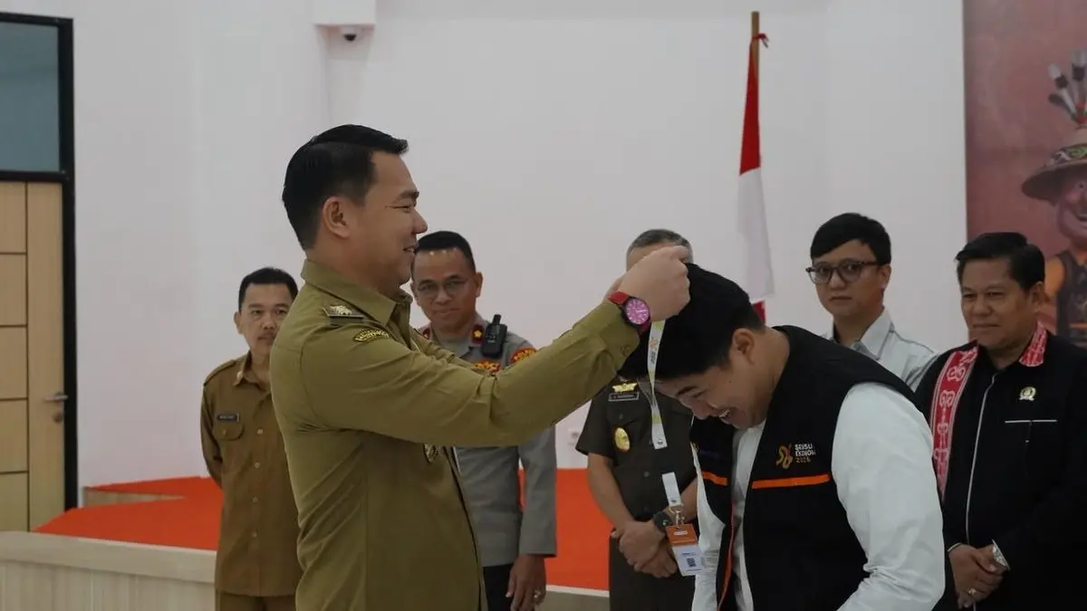 Bupati memasangkan atribut Sensus Ekonomi kepada perwakilan petugas sensus. (ISTIMEWA)