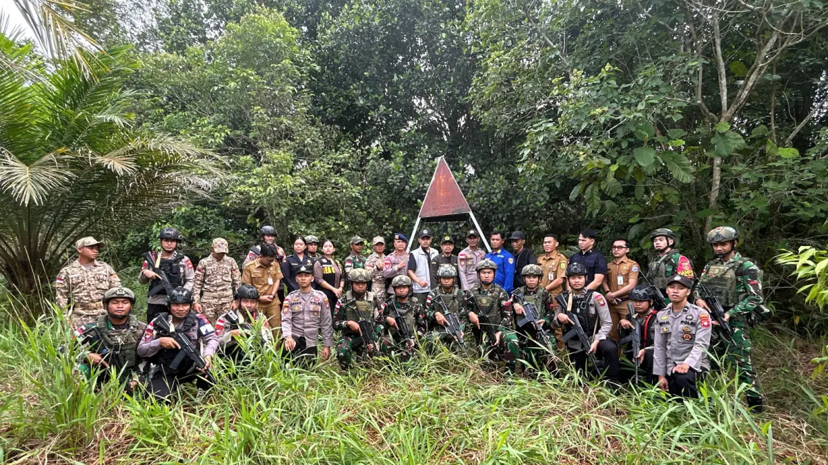 Personel Satbrimob Polda Kalbar berfoto bersama di kawasan hutan perbatasan usai pelaksanaan patroli gabungan dalam Operasi Pengamanan Perbatasan RI–Malaysia, Selasa (23/6/2026), sebagai bentuk sinergi menjaga keamanan wilayah terluar negara. (Istimewa)