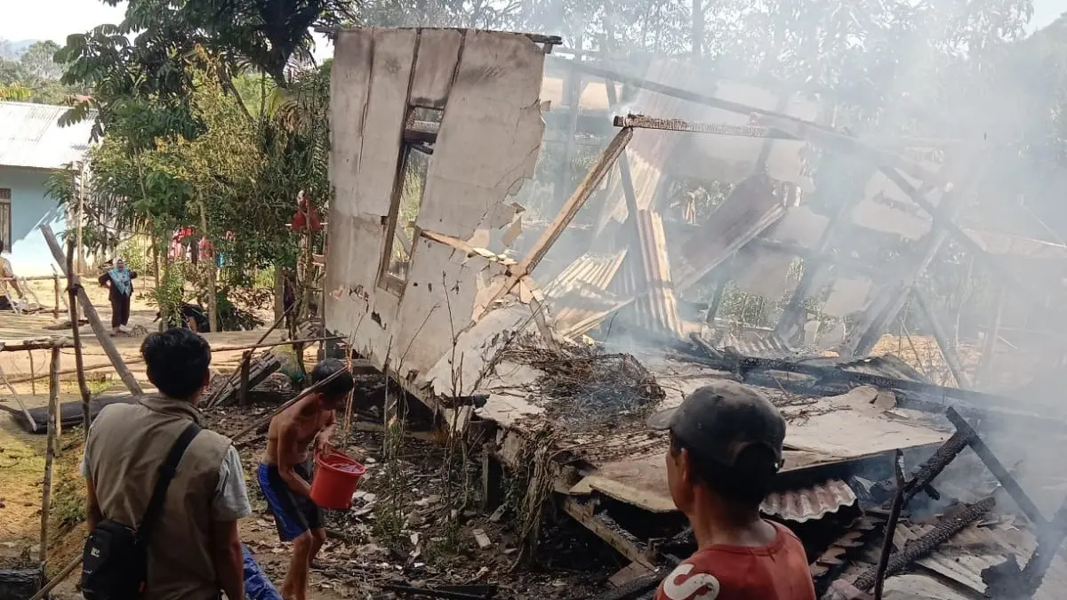 Petugas BPBD bersama warga melakukan pemadaman sisa kebakaran rumah warga di Dusun Labai Mekar, Desa Pintas, Kecamatan Pinoh Selatan, Kabupaten Melawi, yang hangus terbakar akibat dugaan korsleting listrik, Selasa (23/6).