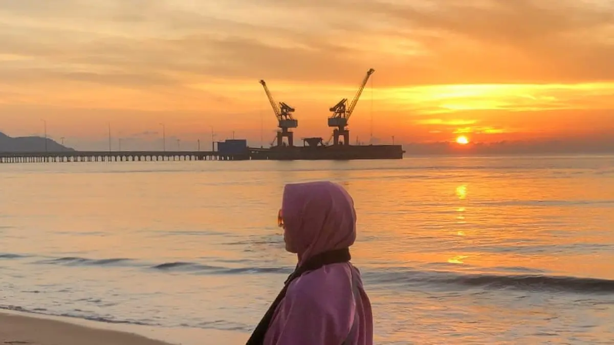 Salah satu pengunjung mengabadikan moment sunset di Pantai Gratis Singkawang