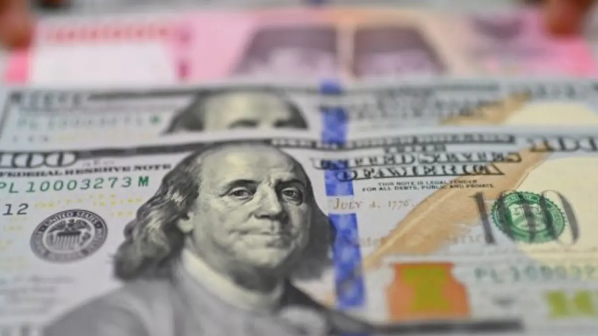 Karyawan memperlihatkan uang pecahan rupiah dan dolar Amerika Serikat (AS) di gerai penukaran mata uang asing Ayu Masagung, Jakarta. (ANTARA FOTO/Indrianto Eko Suwarso/kye)