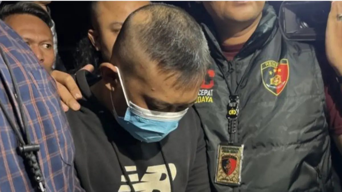 Petugas kepolisian saat menggiring pelaku penganiayaan dan penyekapan yakni Taufik Hidayat untuk menjalani pemeriksaan di Mapolda Jabar, Kota Bandung, Selasa (23/6). (ANTARA/Rubby Jovan)